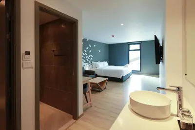 a hotel room with a bed and a bathroom at KOO HOTEL in Ban Bang Talat