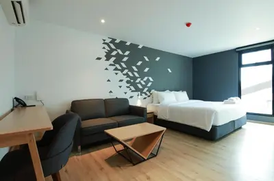 a hotel room with a bed and a couch at KOO HOTEL in Ban Bang Talat