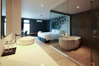 a bathroom with a tub and a bedroom with a bed at KOO HOTEL in Ban Bang Talat