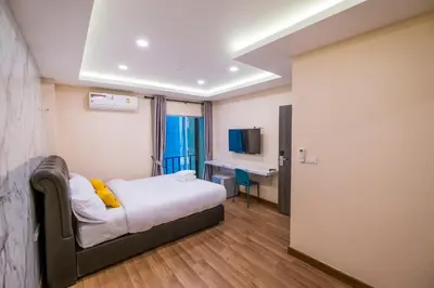 a hotel room with a bed and a desk at Amber Inn in Bangkok