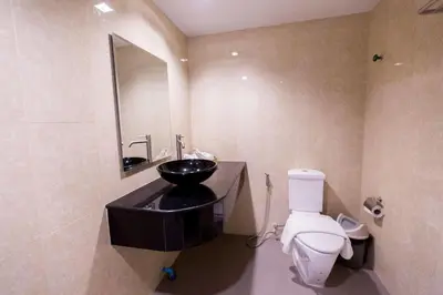 a bathroom with a black sink and a toilet at Royal Asia Hotel Pratunam in Bangkok