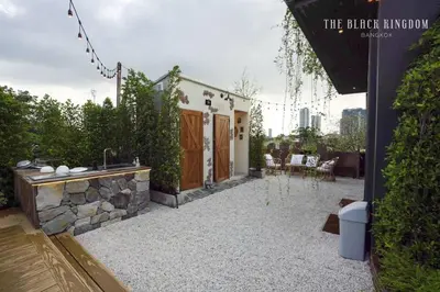 a backyard with a stone tub and a house at The Black Kingdom - เดอะ แบล็ค คิงดอม in Bangkok