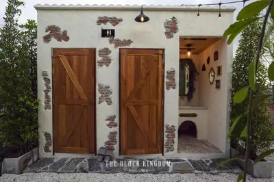 a house with two wooden doors and a fireplace at The Black Kingdom - เดอะ แบล็ค คิงดอม in Bangkok