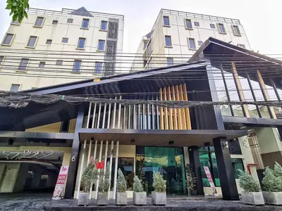 a store front of a building with plants in front at Thana Wisut Hotel in Bangkok