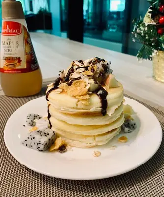 a stack of pancakes on a plate on a table at Thana Wisut Hotel in Bangkok