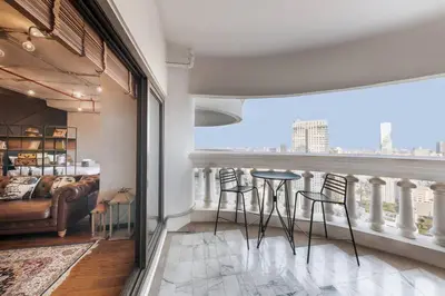 a living room with a balcony with a table and chairs at Central Bangkok Loft Style Skyline 100 sq.m. Apt in Bangkok