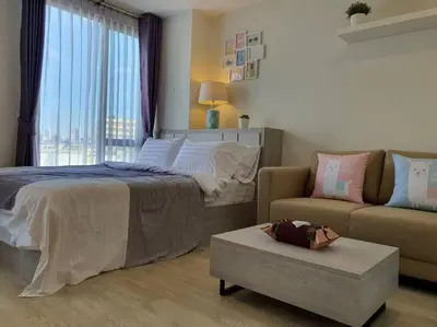 a bedroom with a bed and a couch and a window at I'M Chinatown Residence Yaowaraj Bangkok Watmungkorn MRT Station in Bangkok