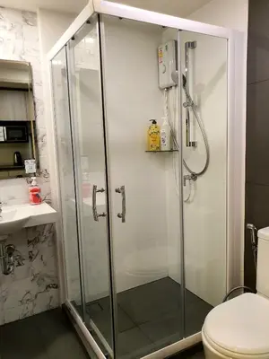 a bathroom with a shower and a toilet at I'M Chinatown Residence Yaowaraj Bangkok Watmungkorn MRT Station in Bangkok