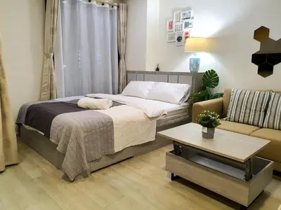 a bedroom with a bed and a couch at I'M Chinatown Residence Yaowaraj Bangkok Watmungkorn MRT Station in Bangkok