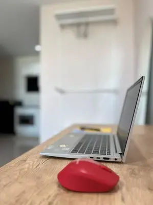 a laptop computer with a red mouse on a table at 29th floor Studio, Cozy Workplace, Long stay, wide space in Amphoe Phra Khanong