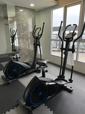 a gym with three elliptical machines in a room at 29th floor Studio, Cozy Workplace, Long stay, wide space in Amphoe Phra Khanong