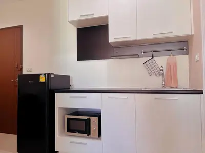 a kitchen with a black refrigerator and a microwave at 29th floor Studio, Cozy Workplace, Long stay, wide space in Amphoe Phra Khanong