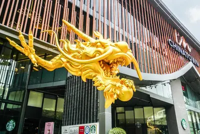 a golden dragon sculpture in front of a building at I'm Chinatown Residence in Bangkok