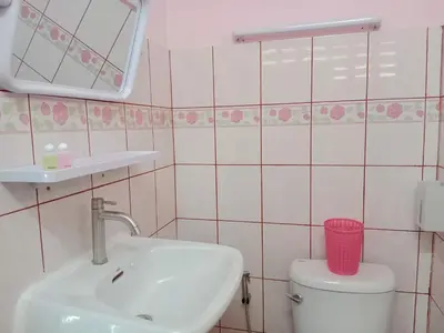 a bathroom with a sink and a toilet and a mirror at Worakarn Apartment 1 in Bangkok