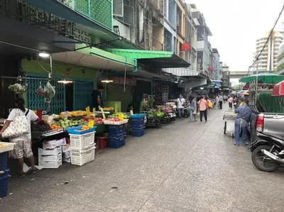 a group of people walking around a market with fruits and vegetables at OnNut Pool Homestay in Amphoe Phra Khanong