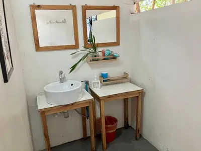 a bathroom with a sink and two tables with a mirror at OnNut Pool Homestay in Amphoe Phra Khanong