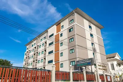 a tall building with a fence in front of it at Siam Rama9 Hotel in Amphoe Phra Khanong