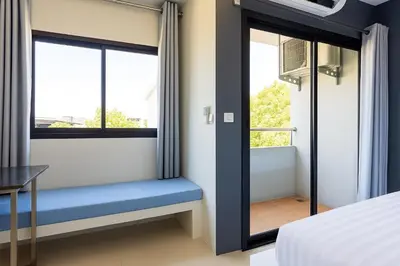 a bedroom with a window seat with a blue bench at Siam Rama9 Hotel in Amphoe Phra Khanong