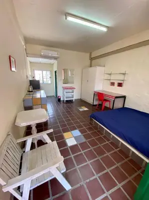 a room with a bed and a table and chairs at Ratanawong Place 520 in Bangkok