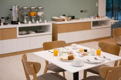 a white table with plates of food and glasses of orange juice at Pure Eleven Hotel Bangkok in Bangkok