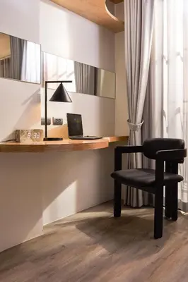 a black chair sitting next to a desk with a laptop at Hotel Sapin in Pom Prap