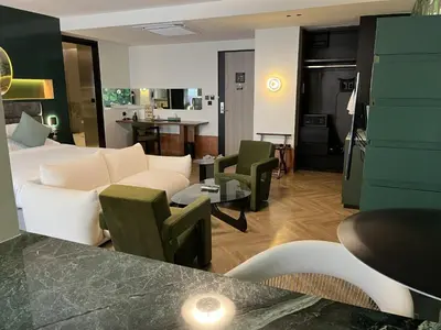 a living room with a white couch and chairs at Hotel Sapin in Pom Prap