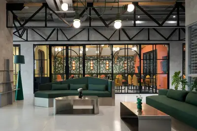 a lobby with two green couches and a table at Hotel Sapin in Pom Prap