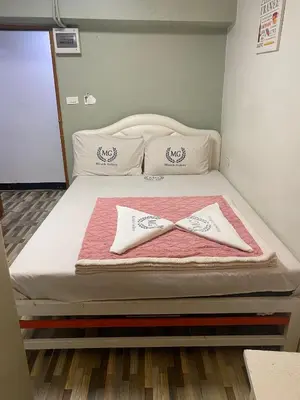 a bed with two pillows and a towel on it at Miracle Gallery Hotel in Makkasan