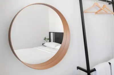 a round mirror in a bathroom with a bed at CASA BLANCA Dusit in Dusit