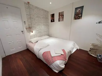 a bedroom with a bed and a brick wall at 77 Old Town in Bangkok