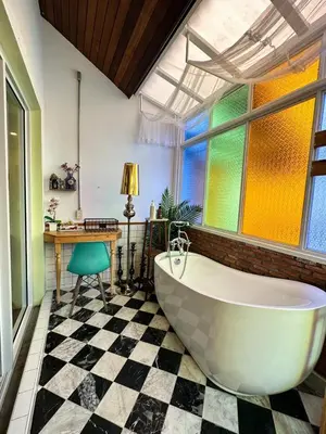 a bathroom with a large white tub and a window at T-House BKK 2Floors near BTS with swimming pool and free Wifi in Khlong Toei