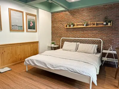 a bedroom with a bed and a brick wall at T-House BKK 2Floors near BTS with swimming pool and free Wifi in Khlong Toei