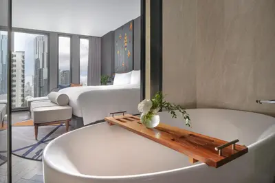 a bathroom with a tub and a bedroom with a bed at InterContinental Bangkok Sukhumvit by IHG in Bangkok
