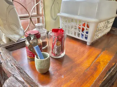a wooden table with jars and a cup on it at DonMueang Boutique House DonMueang Airport in Bangkok