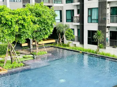a swimming pool in front of a building at Rhythm sukhumvit 36 two bedrooms in Bangkok
