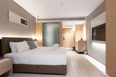 a hotel room with a bed and a television at Laike Hotel in Bangkok