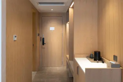 a bathroom with a sink and a door to a room at Laike Hotel in Bangkok