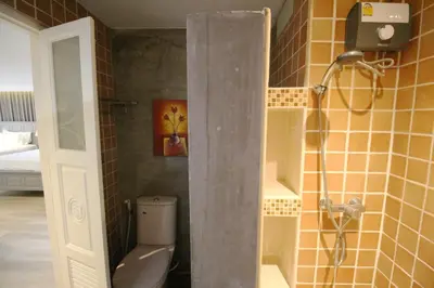 a bathroom with a shower with a toilet in it at SASHA HOUSE in Ban Yang