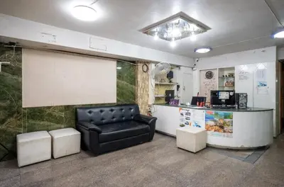 a living room with a black leather couch and a counter at IRAQI HOTEL in Makkasan