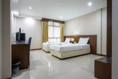 a bedroom with two beds and a flat screen tv at IRAQI HOTEL in Makkasan