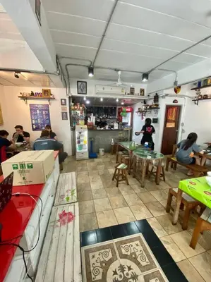 a room with people sitting at tables in a restaurant at Ratanawong Place 304 in Bangkok