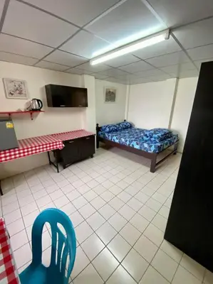 a room with two beds and a chair in it at Ratanawong Place 560 in Bangkok