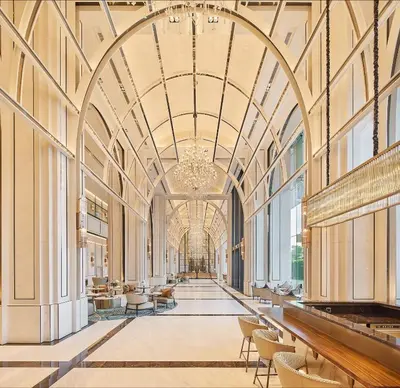a hallway in a building with a chandelier at Eastin Grand Hotel Phayathai in Bangkok
