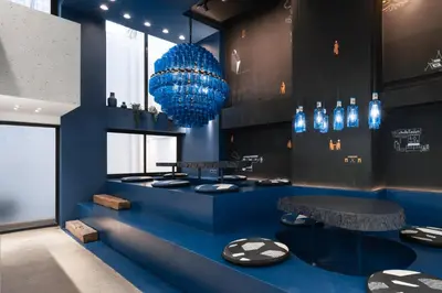 a blue room with two tables and a blue chandelier at Speck Bangkok in Bangkok