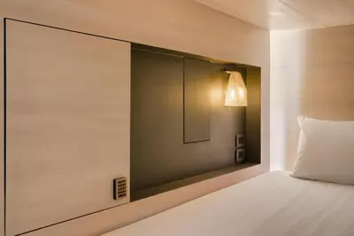 a bedroom with a bed with a light on the wall at Speck Bangkok in Bangkok