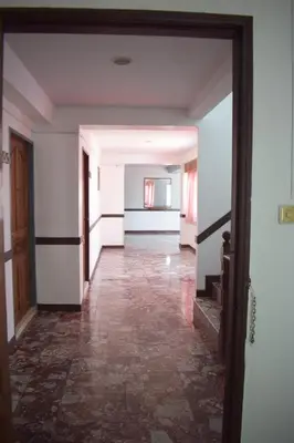 an empty hallway with white walls and a tile floor at My Hotel Bangkok Noi in Bangkok Noi