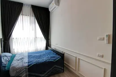 a bedroom with a bed in front of a window at New Condo, Hi-Speed Wi-Fi, Gym Pool, near Lam Sali MRT in Bangkok