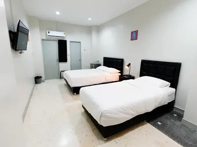 a room with two beds and a flat screen tv at Suksomboon Residence in Bangkok