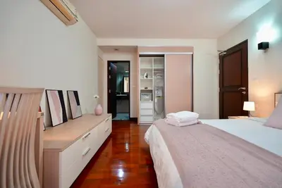 a bedroom with a bed and a dresser in it at Baan Sukhumvit14 in Bangkok