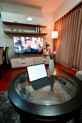 a laptop on a glass table in a living room at Baan Sukhumvit14 in Bangkok